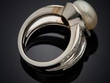 an image of a ring with a pearl and diamonds on a black surface