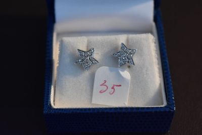 une paire de boucles d'oreilles dans une boîte sur laquelle est apposée une étiquette de prix