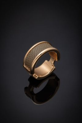 gros plan d'une bague en or sur une surface noire