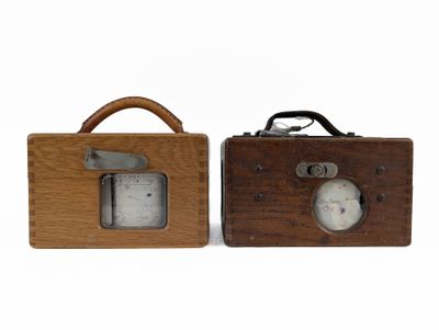 two wooden clocks sitting next to each other on a white surface