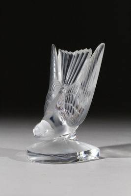 un vase en verre avec un oiseau sur une table