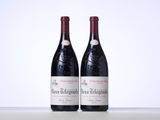 two bottles of red wine sitting next to each other on a table