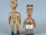 des figurines en bois représentant un homme et une femme, portant chacune une étiquette avec leur nom