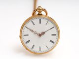 une montre de poche en or avec des chiffres romains sur le cadran