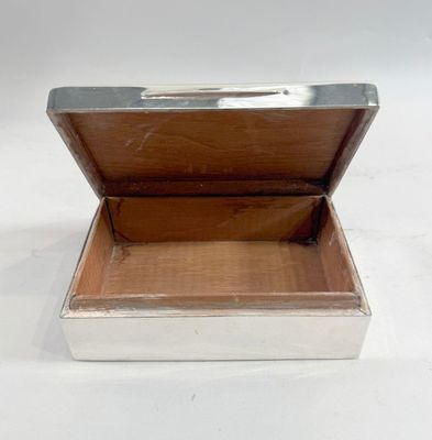 a silver box with a silver lid on a white surface