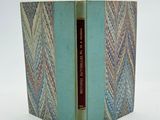 un vieux livre à la couverture bleue posé sur une surface blanche