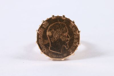 une image représentant une bague en or avec une pièce au milieu