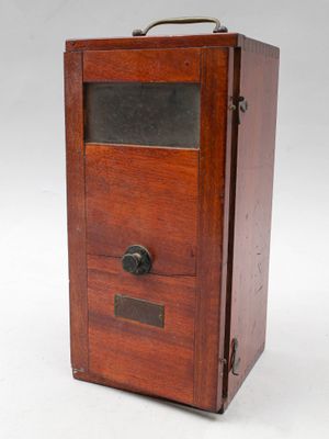 une vieille boîte en bois surmontée d'une porte vitrée