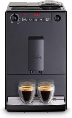 un gros plan sur deux tasses de café devant une machine à expresso