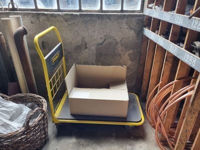 un petit chariot sur lequel se trouve une boîte, dans une pièce