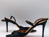 Les chaussures de cette femme sont noires et ornées de nœuds.