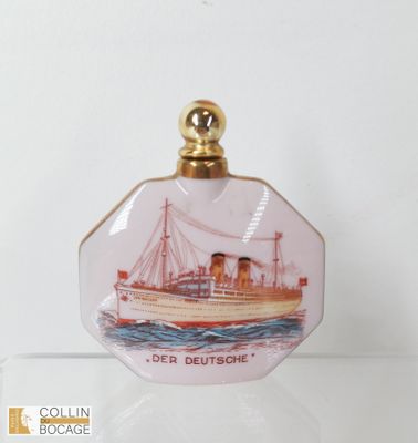 une petite bouteille en verre sur laquelle est représenté un bateau
