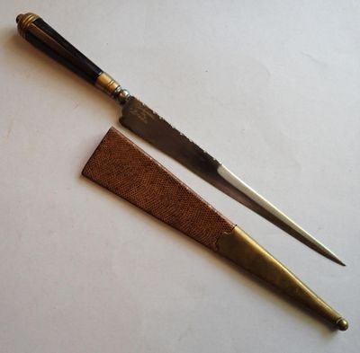 Deux couteaux sont posés l'un sur l'autre sur une table.