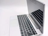 a white laptop with a black keyboard on a white surface