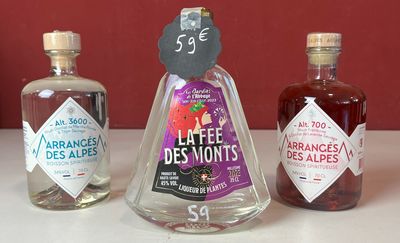 trois bouteilles d'alcool posées sur un plan de travail