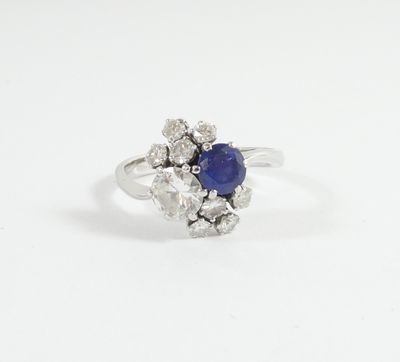 a white gold ring with a blue sapphire and diamonds