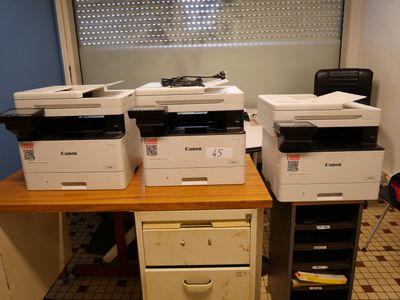 de nombreuses imprimantes posées sur un bureau dans une pièce