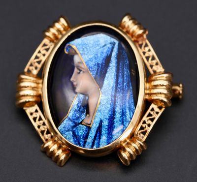 un gros plan sur la photo d'une femme en robe bleue portant une broche dorée