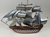 une maquette en métal d'un bateau posée sur un socle en bois