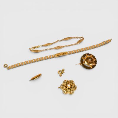 un assortiment de bijoux en or comprenant une chaîne, un bracelet et une broche