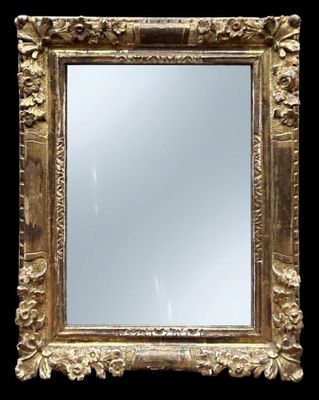un miroir à cadre doré sur fond noir