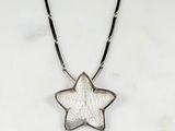 a close up of a necklace with a star pendant on it