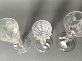 three wine glasses are lined up on a gray surface