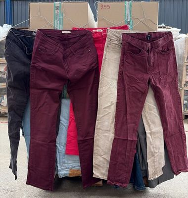 trois paires de pantalons suspendues à un portant devant un entrepôt