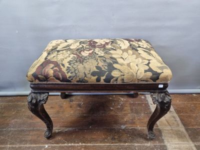 a small foot stool with a floral upholstered seat
