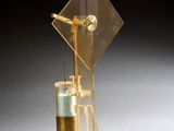 une image représentant un objet en or et en verre surmonté d'une horloge