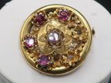 an image of a close up of a gold and pink stone broochle