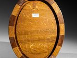 an oval wooden tray with carvings on it sitting on a table