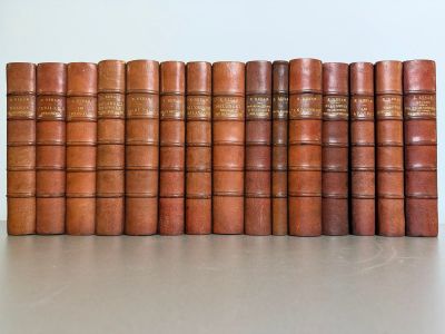 several old books lined up in a row on top of a table