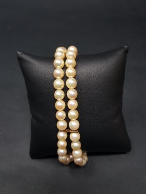 un gros plan d'un bracelet de perles posé sur un coussin