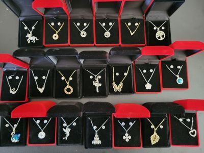 a lot of necklaces and earrings on display in a box
