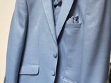 a suit hanging on a hanger in front of a mirror