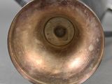 a close up of a metal vase on a table