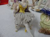 a figurine of a woman sitting on a chair