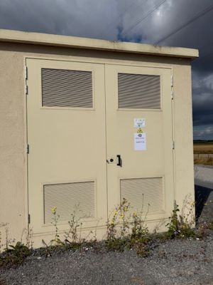 two doors on the side of a building on the side of the road
