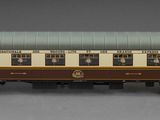 un wagon marron et blanc posé sur une surface grise