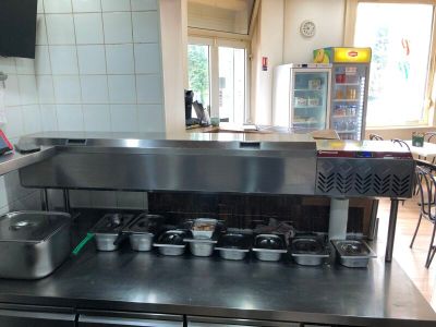 un plan de travail en acier inoxydable sur lequel sont posés des casseroles et des poêles, dans une cuisine