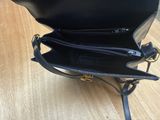 the inside of a black purse sitting on top of a wooden floor