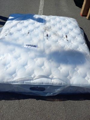 un matelas posé à même le sol sur le parking