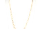 un collier de perles blanches sur un mannequin avec un fermoir en or