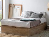 un lit avec une tête de lit en bois et une couverture posée dessus