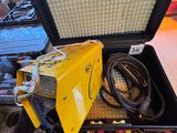 un poste à souder jaune posé dans un coffret au sol