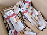 a box full of wooden clothes pegs and clothes pins
