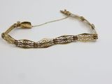 un bracelet en or au motif très travaillé sur fond blanc