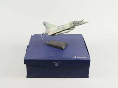 une maquette d'avion de chasse posée sur une boîte bleue