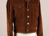 La veste est marron et blanche, avec un col en fourrure.